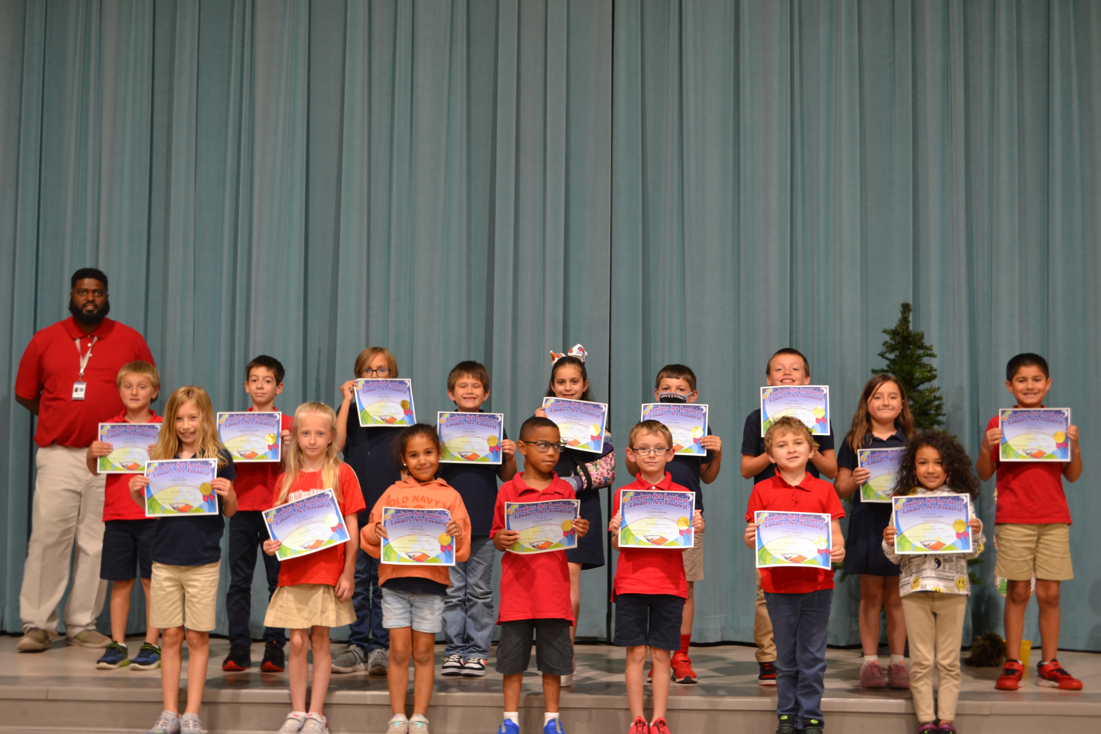 Readers are Leaders award recipients pose together with certificates  on a stage