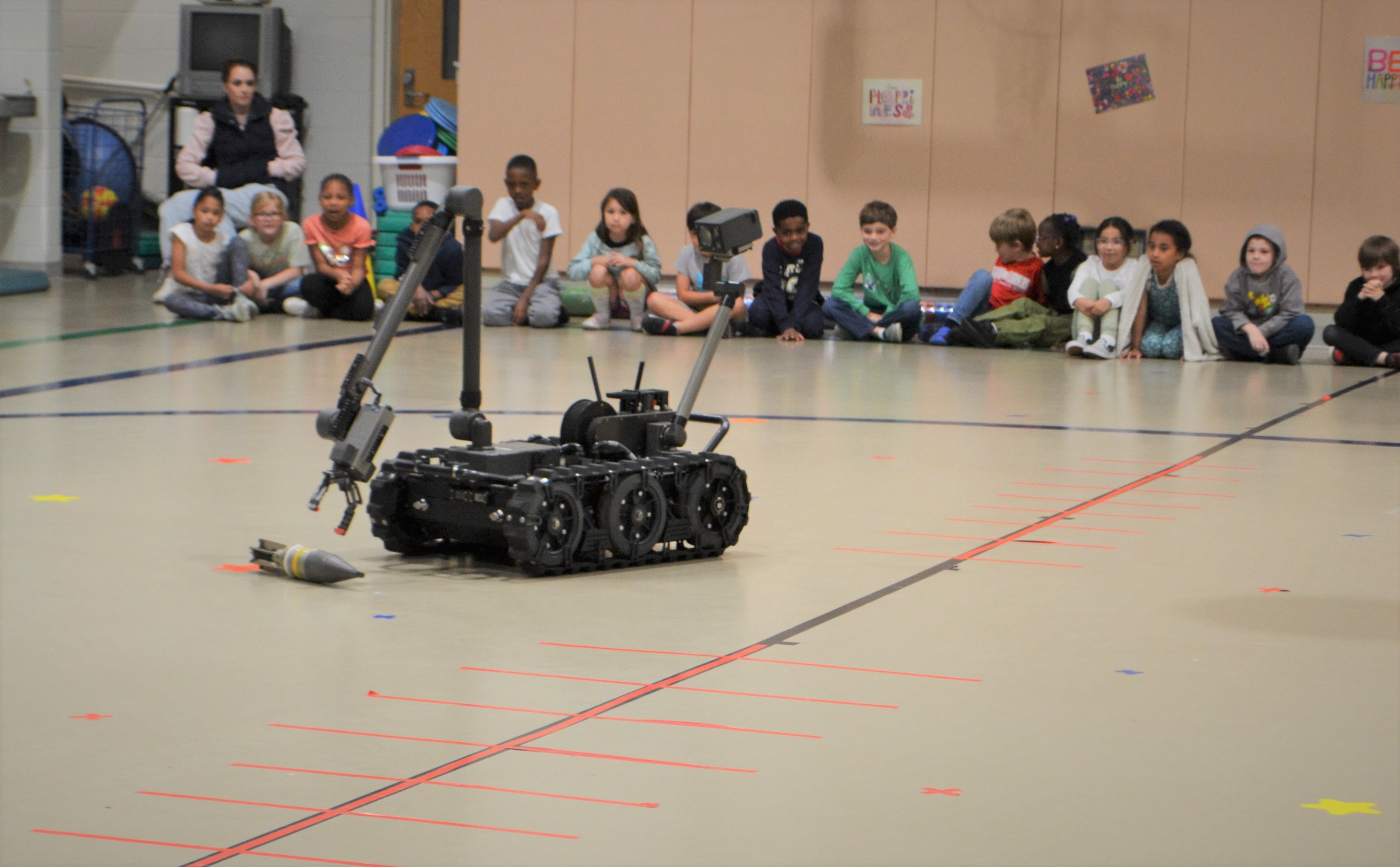 Students watch as an EOD robot shows off how it can handle dangerous objects 