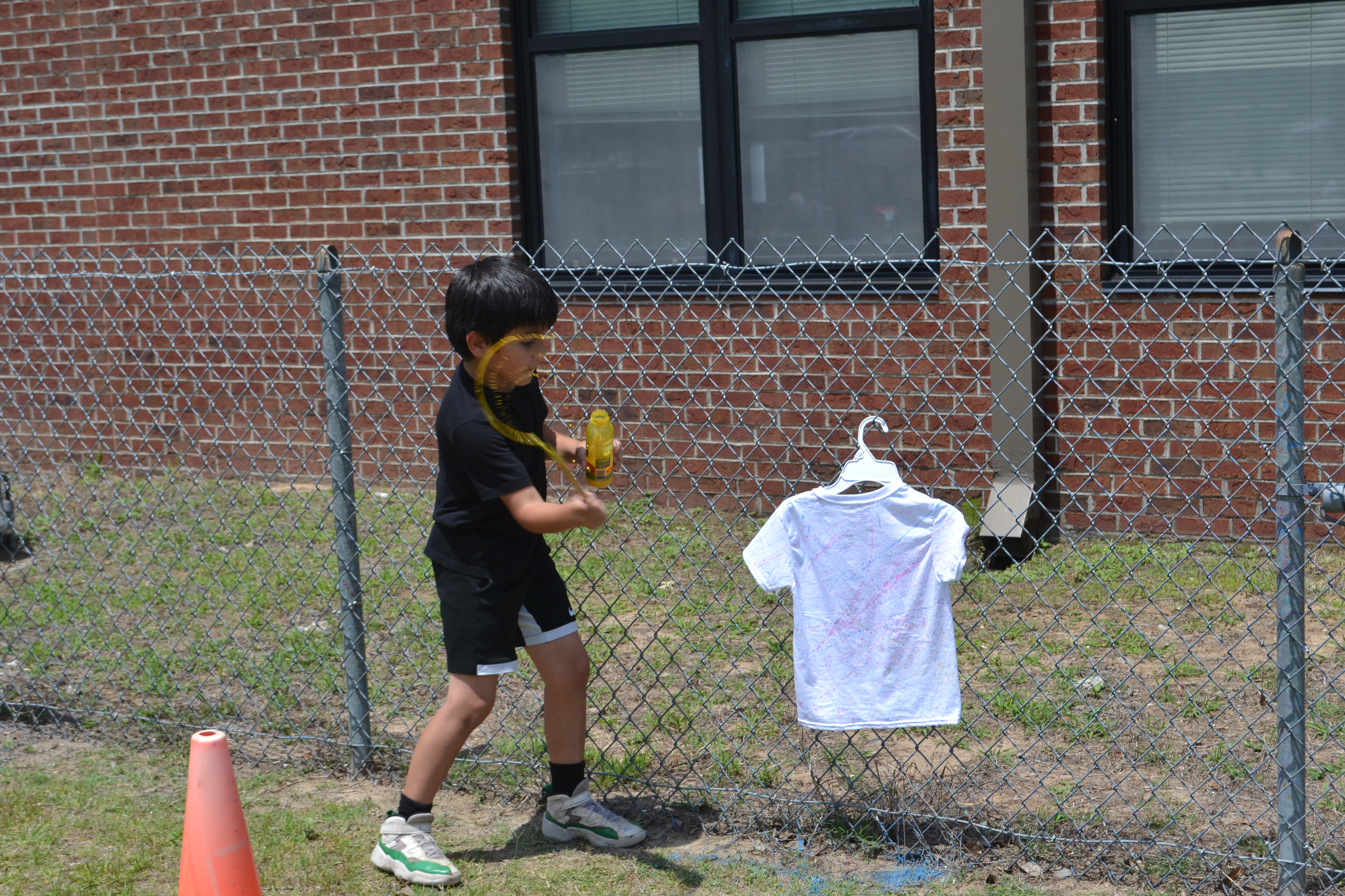 Student splatter paints a shirt