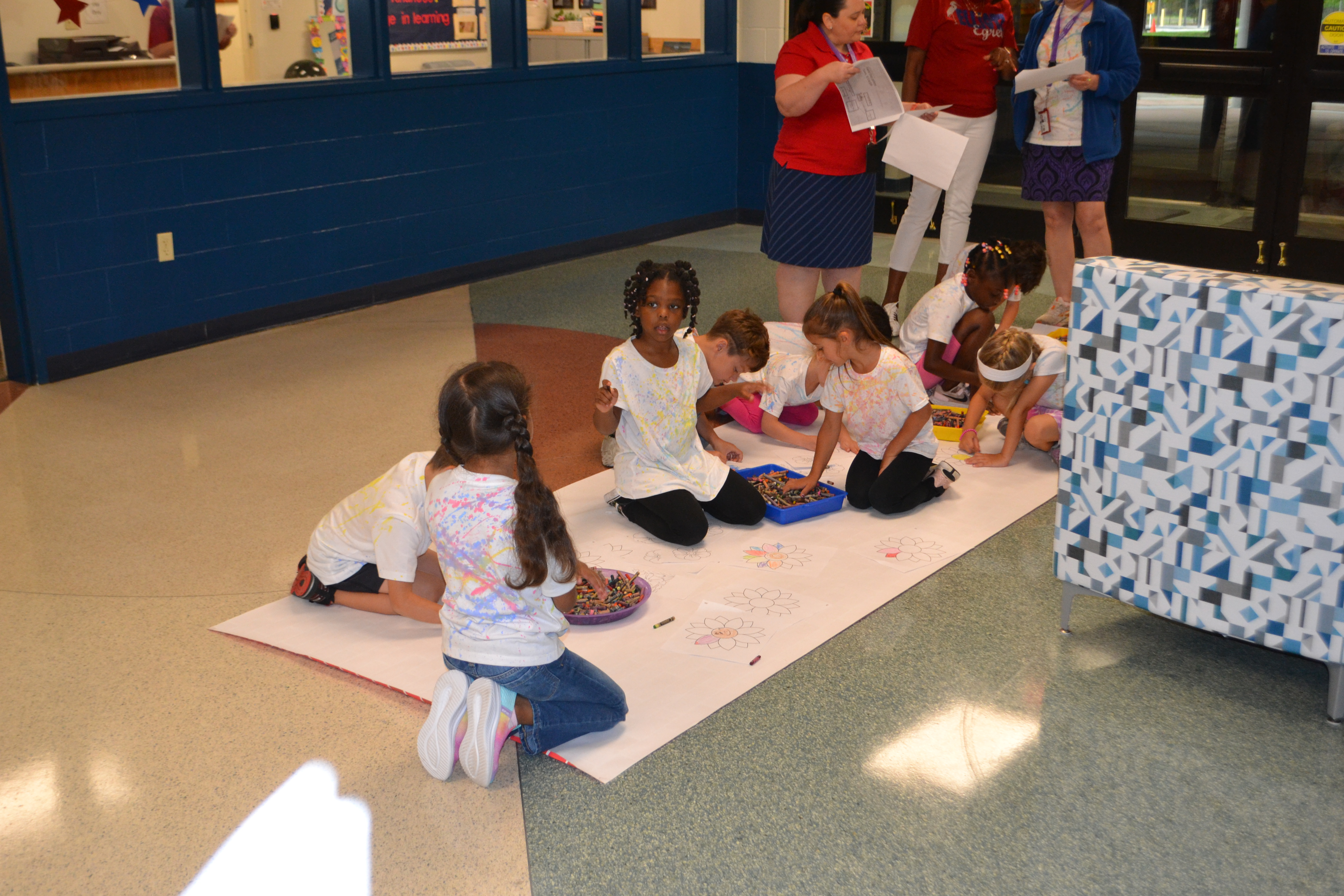 Students draw on a giant piece of paper