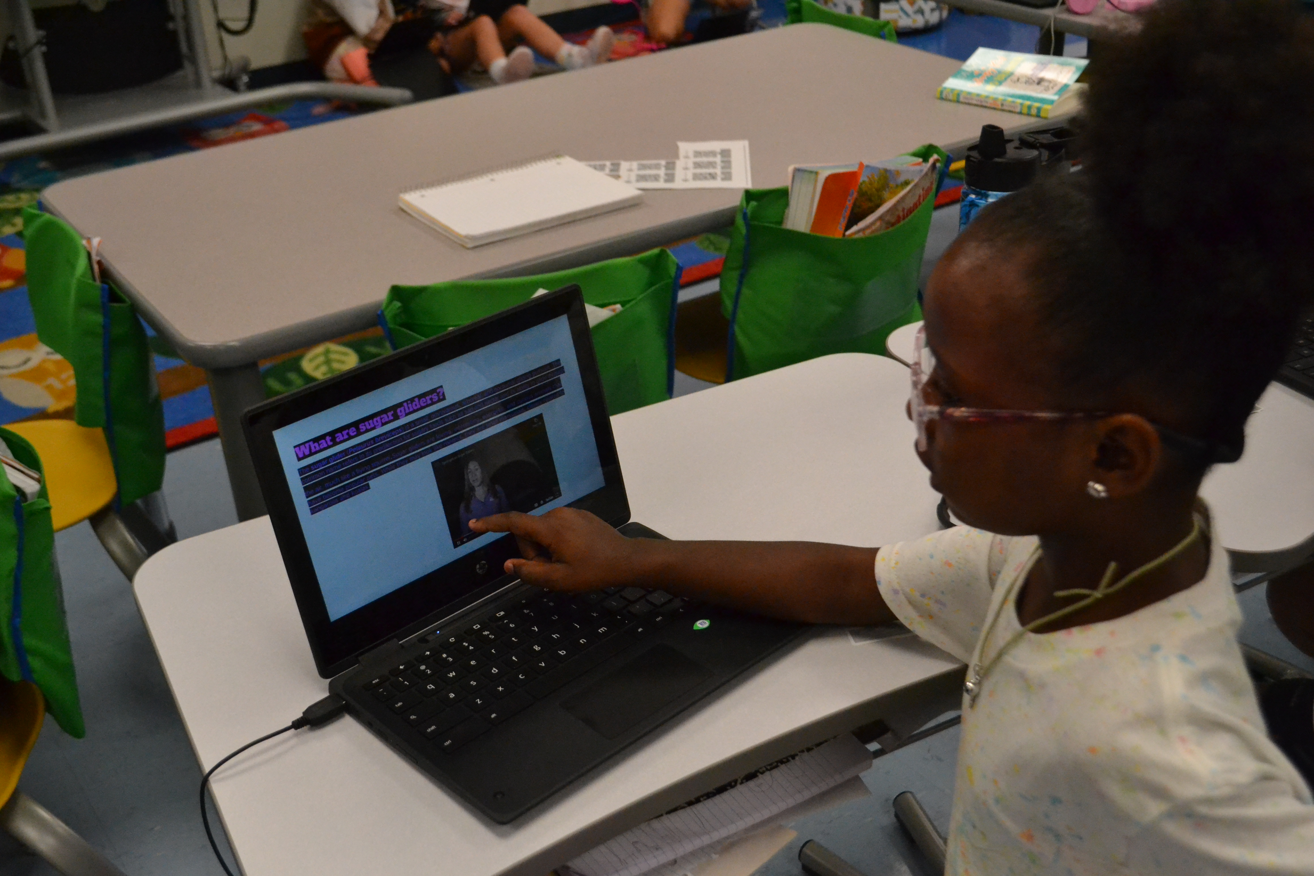 Students gestures towards her power point presentation about sugar gliders 