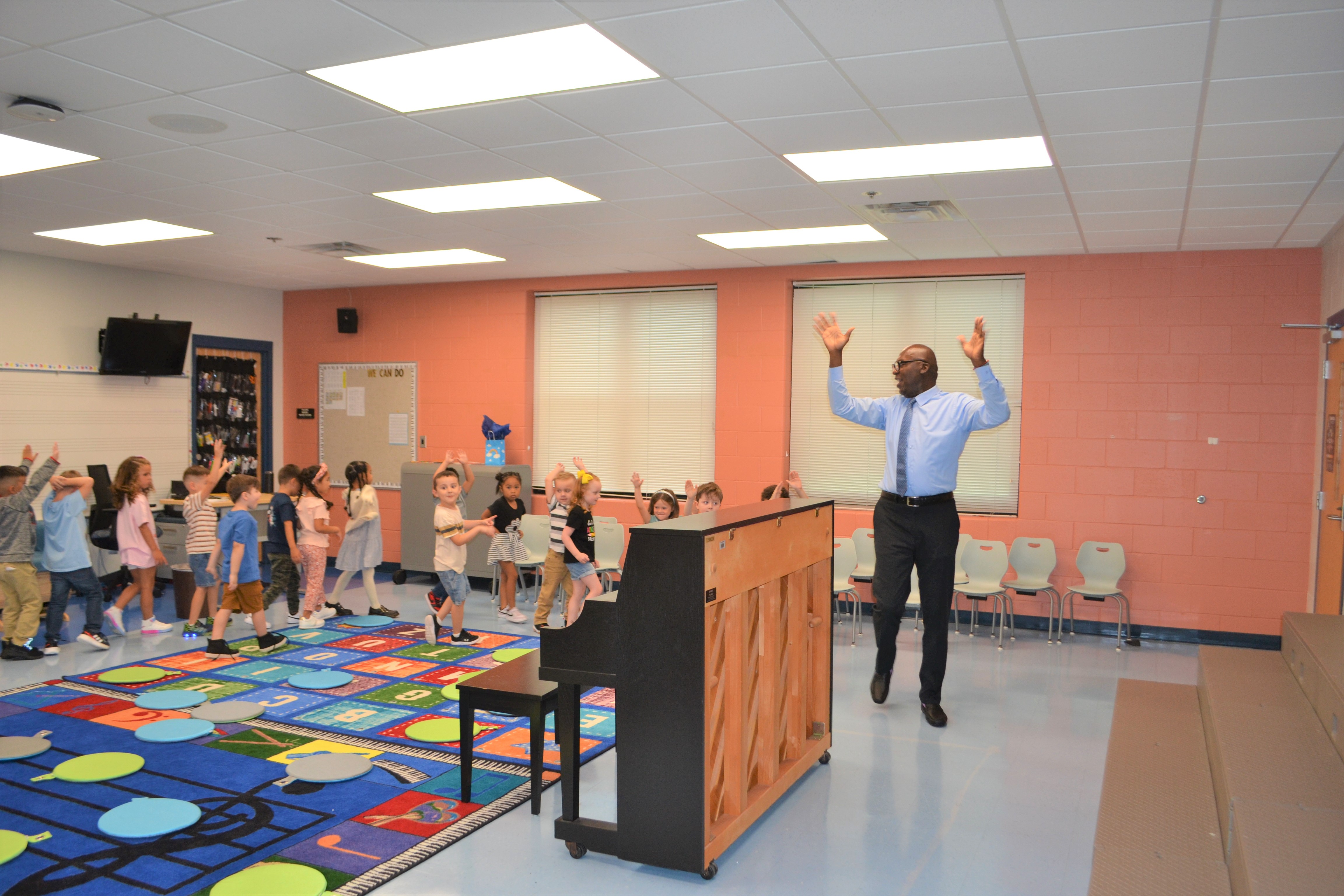 The Music teacher leads students through a follow the leader activity