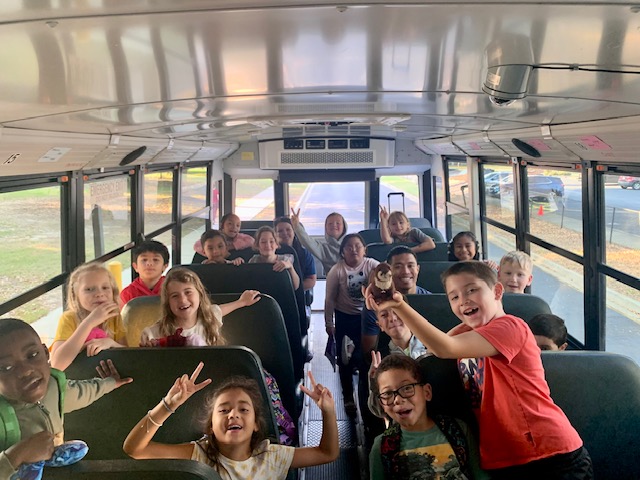 2nd Graders pose excitedly on the bus before their aquarium adventure