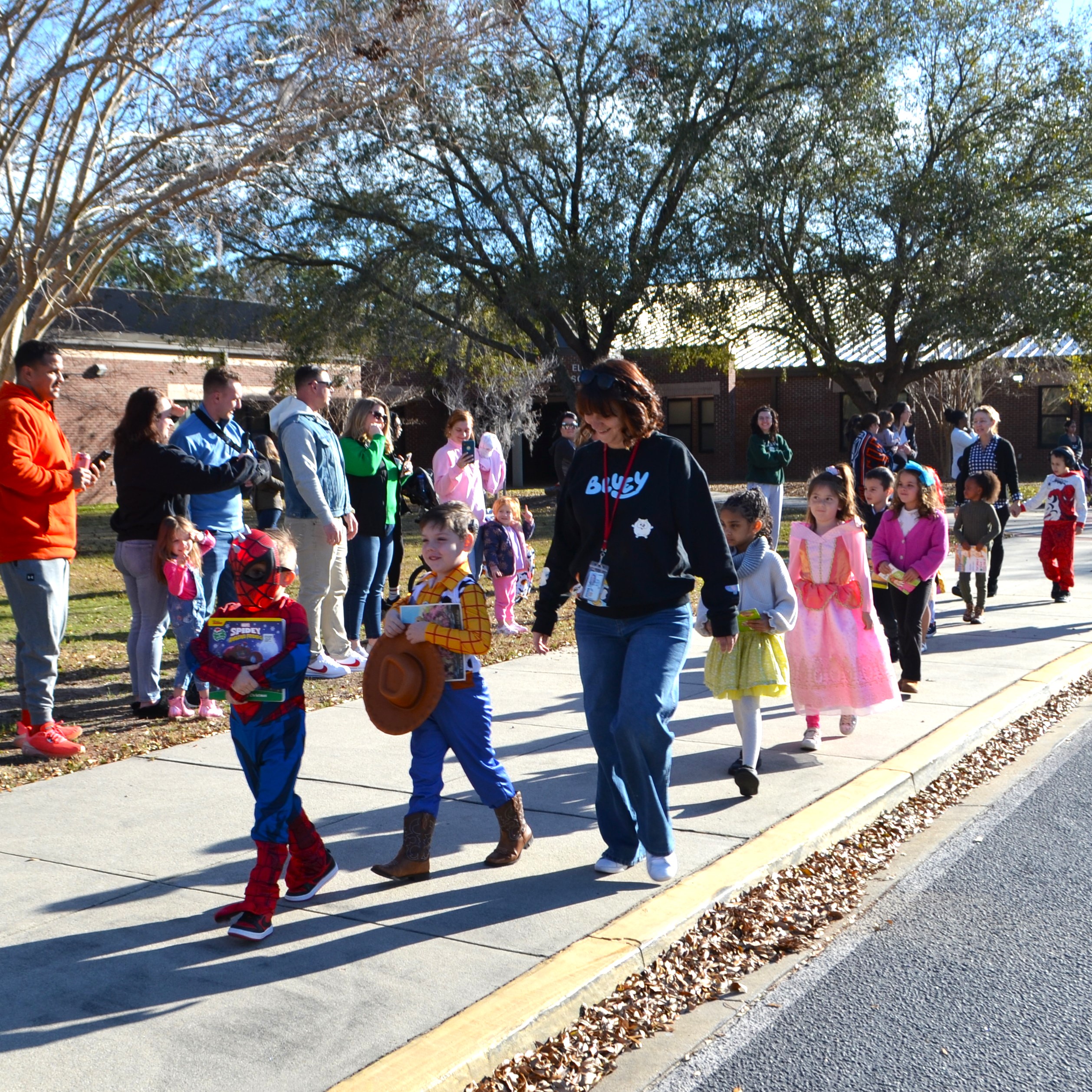 Students dressed as favorite book characters parade in front of the school