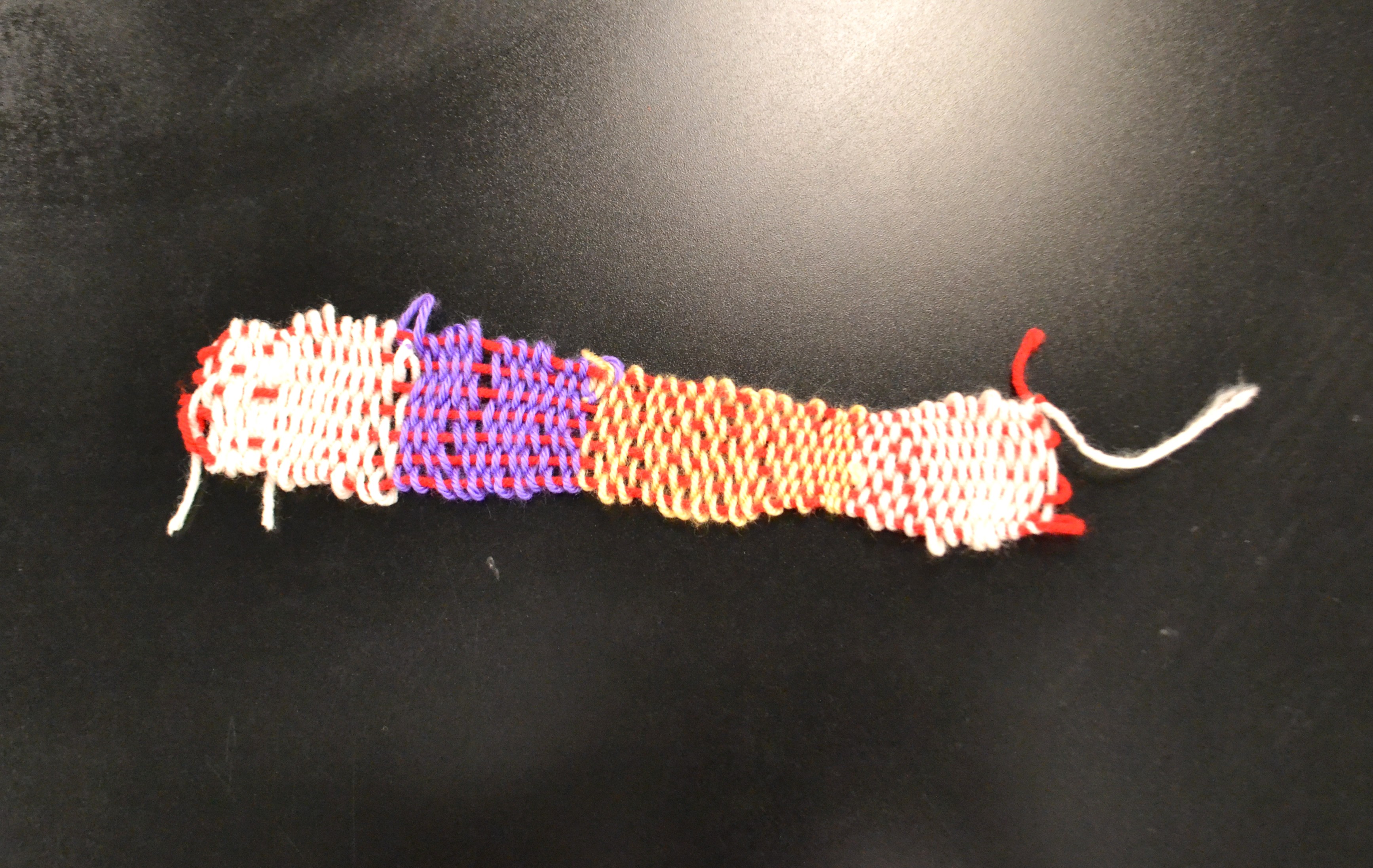 Finished, multicolored weaving project using acrylic yarn